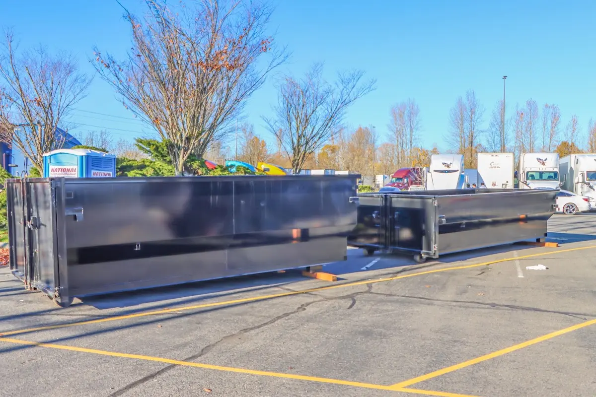 Professional dumpster rental service with roll-off container on residential driveway in Eastham